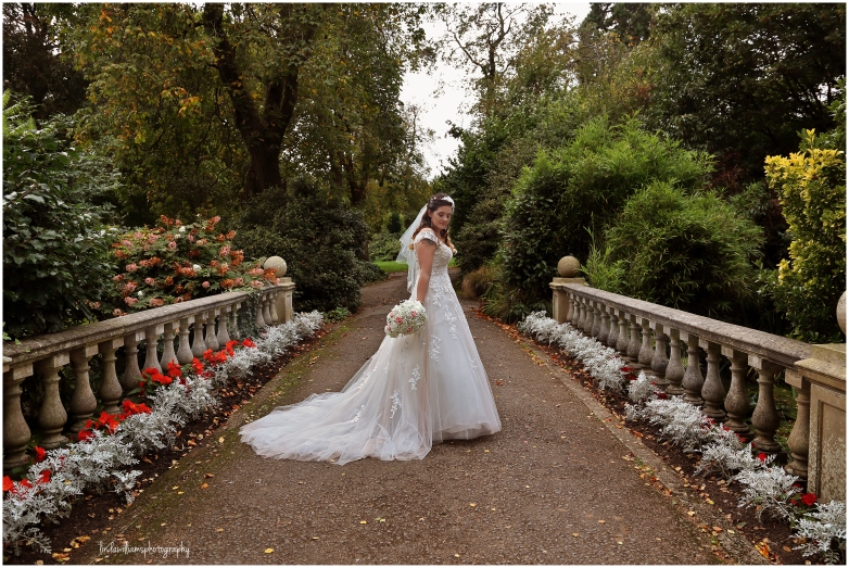 Beautiful bride standing in Dewstow Gardens