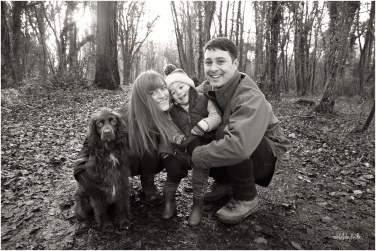 black and white photo of family with their dog