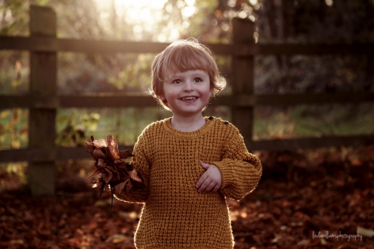 little boy in the autumn leaves