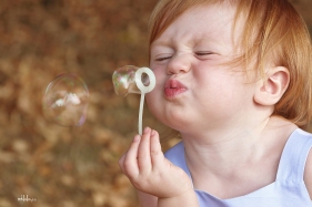 portrait of little girl blowing bubbles