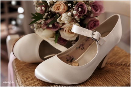 brides shoes and bouquet at home in Undy